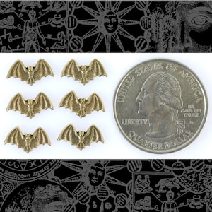 May include: Six gold-colored bat charms, each with a wingspan of about 1 inch. The charms are arranged in two rows of three. A US quarter dollar is included for scale.