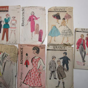 May include: A collection of vintage sewing patterns, including Butterick and Advance brands. The patterns feature various designs for dresses, skirts, tops, and aprons. The patterns are printed on paper and have illustrations of the finished garments.