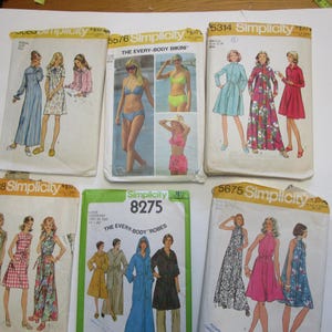 May include: Six vintage sewing patterns for women's clothing. The patterns are from Simplicity and feature designs for robes, bikinis, and dresses. The patterns are printed on white paper with black and red text.