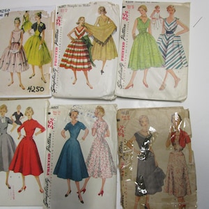 May include: Five vintage Simplicity sewing patterns for dresses. The patterns are printed on paper and feature illustrations of women wearing the dresses. The patterns are all priced at 35 cents.