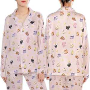 May include: Pink pajama set with a repeating pattern of cartoon characters, clouds, and crescent moons. The long-sleeved top has a button-down front and white trim. The matching pants complete the sleepwear ensemble.