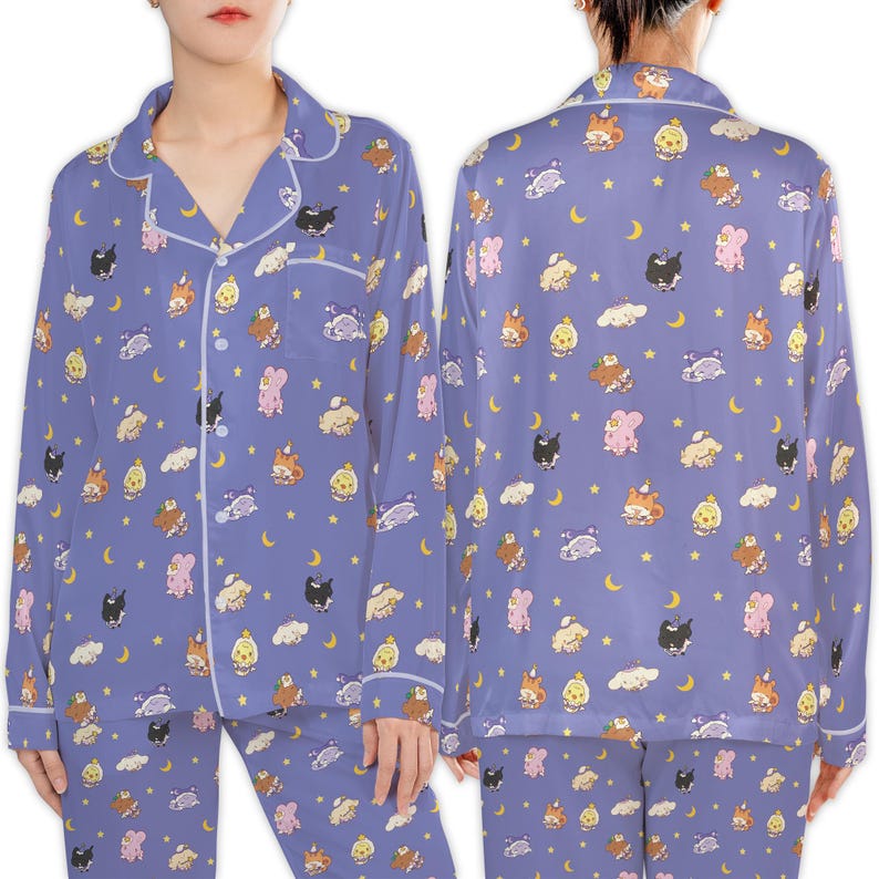May include: A two-piece pajama set in a periwinkle blue color, featuring a repeating pattern of cartoon animals, moons, clouds, and stars. The long-sleeved top has a button-down front with white trim, and the matching pants complete the set.