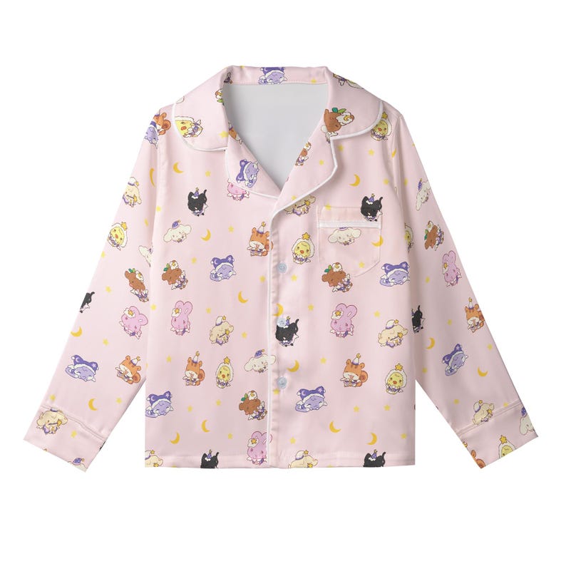 May include: Pink pajama top with a repeating pattern of cartoon characters, moons, and stars. The long-sleeved top has a collared neckline, a chest pocket, and white trim. The pajama top is button-down.