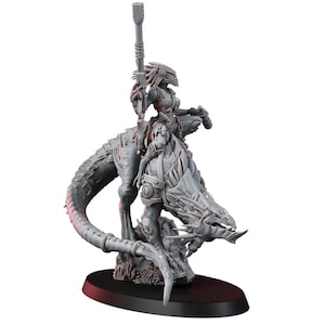 May include: A grey miniature figure of a warrior riding a reptilian creature, holding a rifle. The warrior is clad in armour and a helmet. The creature has a long tail and sharp claws. The figure is mounted on a black oval base.