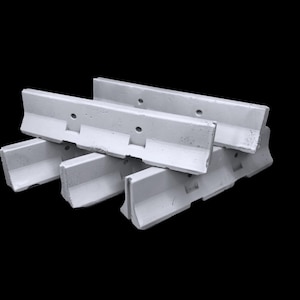 May include: A set of three light gray concrete jersey barriers stacked in a cluster. Each barrier features a distinct L-shaped profile with a wide base, a vertical wall section, and two circular holes positioned along the upper edge of the wall.