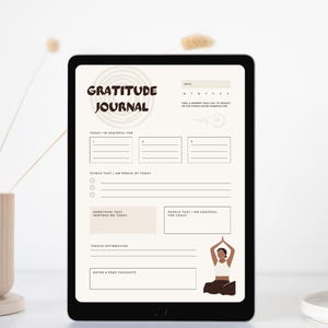 Könnte beinhalten: Ein digitales Dankbarkeitstagebuch auf einem Tablet. Das Tagebuch trägt den Titel "Gratitude Journal" in einer Retro-Schriftart und enthält Aufforderungen für tägliche Reflexionen. Eine minimalistische Illustration einer Person in Yoga-Pose befindet sich unten.