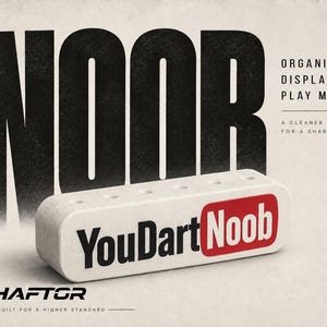 May include: A white rectangular dart holder with five circular holes on top, featuring the black and red text YouDartNoob. The background displays the large black text NOOR, the phrase ORGANIZE. DISPLAY. PLAY MORE., and the brand name SHAFTOR.