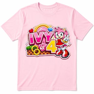 May include: A light pink t-shirt featuring a graphic of the character Amy Rose from Sonic the Hedgehog. The design includes the text "IVY is 4" in bold pink and yellow letters, surrounded by golden rings, a blue gem, and a heart-shaped icon.