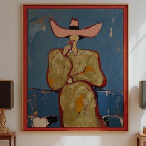 May include: A large rectangular framed painting featuring an abstract figure wearing a wide-brimmed pink hat and a gold-toned garment, holding a small red glass against a deep blue background, enclosed within a bold red frame on a white wall.