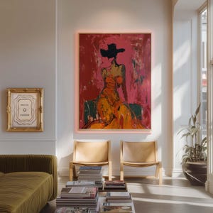May include: An abstract painting of a woman in an orange dress and black hat against a red background. The artwork is framed and hangs above two wooden chairs. A smaller framed piece with the text "PRESS FOR CHAMPAGNE" is also visible.