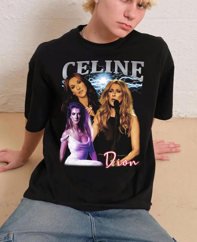 May include: Black t-shirt featuring a graphic of Celine Dion with the text "CELINE" above the images and "Dion" in a neon-style font below. The graphic includes three images of the singer with a lightning bolt background.