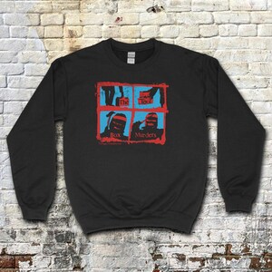 Puede incluir: Sudadera negra de cuello redondo con un gráfico rojo y azul. El gráfico presenta un diseño de cuatro paneles con las palabras "The Tool" y "Box Murders". La sudadera está hecha de un material suave.