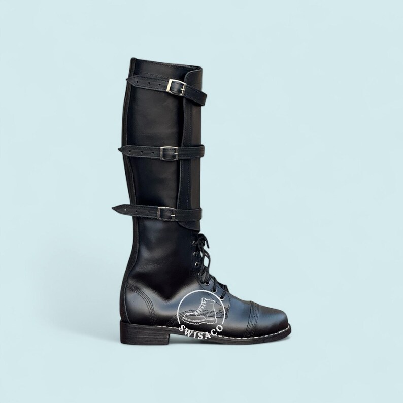 May include: Black leather knee-high boot with three buckle straps and lace-up closure. The boot features a cap toe design and a small heel. The brand logo is visible on the side of the boot.