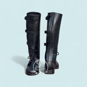 May include: A pair of black leather riding boots. The boots have a tall shaft, lace-up fronts, and buckle closures. The boots are designed for equestrian activities and feature a classic, functional design.