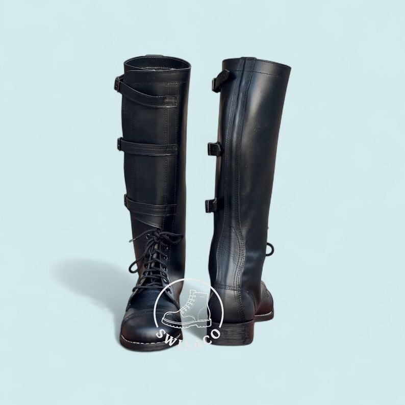 May include: A pair of black leather riding boots. The boots have a tall shaft, lace-up fronts, and buckle closures. The boots are designed for equestrian activities and feature a classic, functional design.
