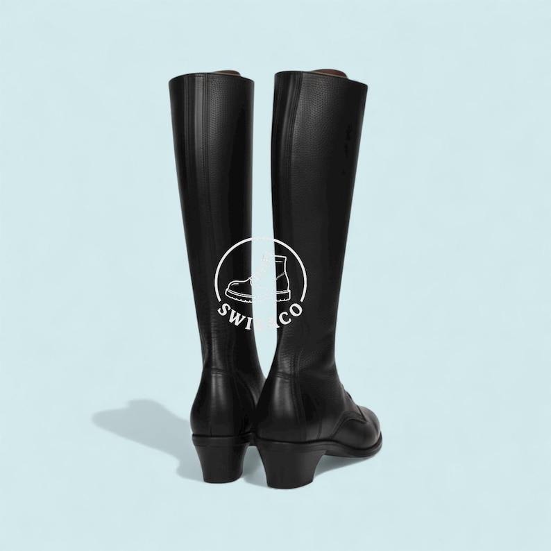 K&ouml;nnte beinhalten: Ein Paar hohe, schwarze Lederreitstiefel. Die Stiefel haben ein klassisches Design mit runder Spitze, mittelhohem Absatz und hohem Schaft. Der Hintergrund ist hellblau. Das Logo "swi co" ist sichtbar.