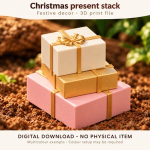 Op de afbeelding: Een stapel van drie rechthoekige geschenkdozen met de tekst Christmas present stack Festive decor 3D print file en DIGITAL DOWNLOAD NO PHYSICAL ITEM. De bovenste doos is wit met een gouden strik, de middelste is goud en de onderste is roze.