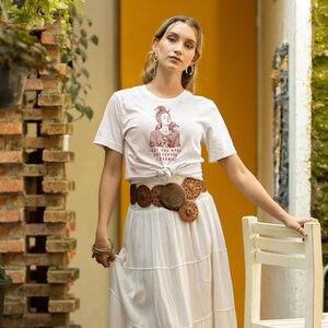 以下が含まれることがあります： 白のセラミックマグカップ、黒いハンドル、手書き風の「But First, Coffee」の文字。マグカップは白い表面に置かれています。マグカップの高さは10cmです。