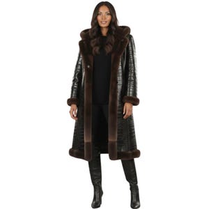 May include: A long, black faux-leather coat with a crocodile skin texture. The coat features brown fur trim around the hood, collar, and cuffs. The coat is buttoned up and reaches the ankles.