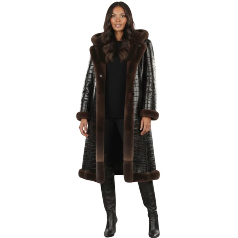 May include: A long, black faux-leather coat with a crocodile skin texture. The coat features brown fur trim around the hood, collar, and cuffs. The coat is buttoned up and reaches the ankles.