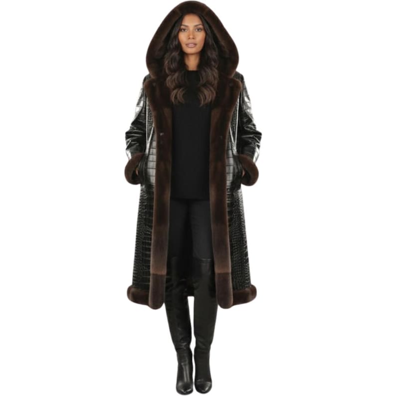 May include: A long black coat with a hood and brown fur trim. The coat has a crocodile skin pattern and is worn with black boots. The hood and cuffs are lined with brown fur.