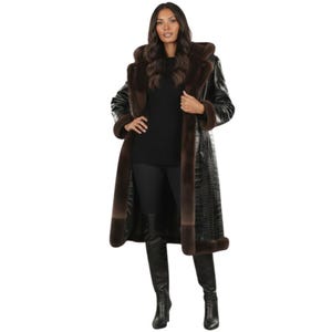 May include: A long black coat with brown fur trim and a hood. The coat has a crocodile skin texture and is worn over a black outfit. The fur trim is around the hood, cuffs, and down the front of the coat.