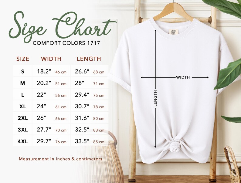May include: White t-shirt hanging on a wooden hanger, with a size chart to the left. The size chart shows measurements in inches and centimeters for sizes S to 4XL. The shirt's width and length are indicated with arrows.