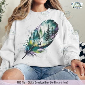 May include: White sweatshirt with a vibrant feather design. The artwork depicts a forest scene with trees, a deer, and a palette of green, blue, and purple. The text at the bottom reads "PNG File - Digital Download Only (No Physical Item)."