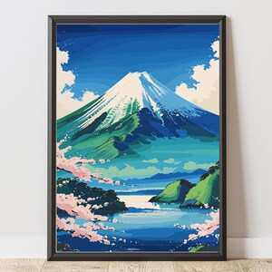以下が含まれることがあります： 雪をかぶった山頂、緑の斜面、青い湖がある富士山の様式化されたイラストが描かれた、額装されたアートプリント。 ピンクの桜が前景を飾り、青い空と白い雲が上部にあります。 アートワークは黒いフレームに入っています。