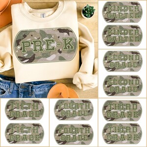 Könnte beinhalten: Cremefarbenes Pre-K-Sweatshirt mit Camouflage-Design. Das Sweatshirt wird mit Jeans und Sandalen kombiniert. Gezeigt werden auch dog-tag-förmige Grafiken mit Klassenstufen: Kindergarten, 2., 3., 4. und 5. Klasse.