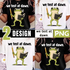 May include: Four t-shirts, two black and two white, each featuring a cartoon frog holding a pencil and a book. The text "we test at dawn" is printed above the frog. The image also includes the words "2 DESIGN" and "PNG".