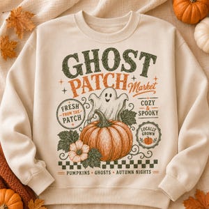 Peut inclure: Un sweat-shirt à col rond couleur crème avec une impression graphique portant le texte GHOST PATCH Market, Fresh From The Patch, Cozy & Spooky et Locally Grown. Le motif comprend une citrouille centrale, un fantôme, des feuilles et une bordure à carreaux.