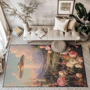 May include: A rectangular area rug featuring a surreal landscape with a golden UFO emitting a beam of light. The rug's design includes a mountain range, flowers, and a sky with clouds. The rug is placed on a wooden floor.