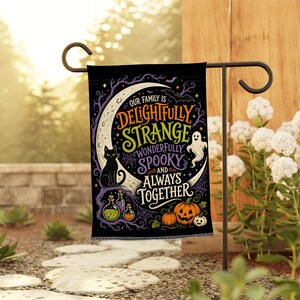 Könnte beinhalten: Eine schwarze rechteckige Gartenflagge mit einem großen weißen Halbmond, einer schwarzen Katze, einem weißen Geist, orangefarbenen Kürbissen und Zaubertrankflaschen. Der Text lautet: Our family is delightfully strange, wonderfully spooky and always together.