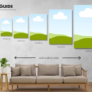 May include: A size guide displays canvas art prints in various sizes, from 12x18 inches to 40x60 inches. Each print features a blue sky with a white cloud and green rolling hills. A sofa, 96 inches wide, is shown for scale.