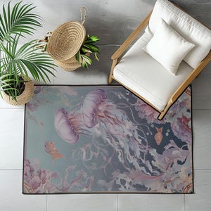 Peut inclure: Tapis rectangulaire avec un motif aquarelle de deux m&eacute;duses violettes et blanches, avec des tentacules fluides. Le tapis a un fond bleu-vert et gris avec des accents floraux et de poissons. Un panier tress&eacute;, une chaise et une plante en pot sont en arri&egrave;re-plan.