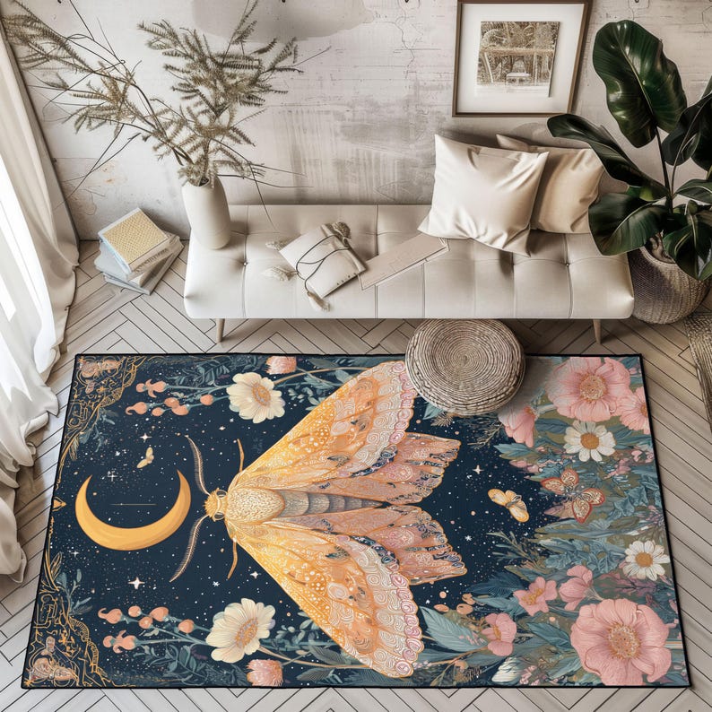May include: A rectangular area rug with a large moth design. The moth has yellow and pink wings, a crescent moon, and floral and celestial elements on a dark blue background. The rug is surrounded by a black border.