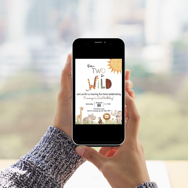 May include: A smartphone displays a birthday invitation with a safari theme. The text reads "Born Two Be Wild" with illustrations of a giraffe, hippo, lion, and elephant. The invitation includes the date, time, and location for the party.