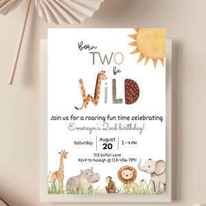 May include: A white invitation card with the text "Born Two Be Wild" and a watercolor illustration of a giraffe, sun, and other safari animals. The invitation is for Emersyn's 2nd birthday, with the date August 20th and time 2-4 PM.