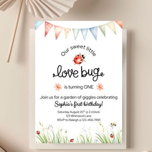 Op de afbeelding: Een witte uitnodigingskaart met een aquarelontwerp. De tekst luidt "Our sweet little love bug is turning ONE" met een lieveheersbeestje-illustratie. De uitnodiging is voor Sophia's eerste verjaardag, met evenementdetails.