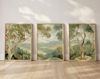 Könnte beinhalten: Drei gerahmte Landschaftskunst-Drucke. Jeder Druck zeigt eine Aquarellmalerei einer hügeligen grünen Landschaft mit Bäumen. Das Kunstwerk ist in Grün-, Blau- und Beigetönen gehalten und hat einen hellen Holzrahmen.