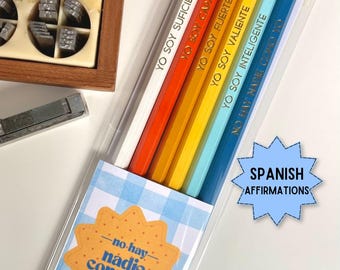 May include: A set of six pencils in a clear plastic sleeve, featuring a white, orange, yellow, light blue, and dark blue color gradient. Each pencil is printed with Spanish text including YO SOY SUFICIENTE, YO SOY CAPAZ, YO SOY FUERTE, YO SOY VALIENTE, YO SOY INTELIGENTE, and NO HAY NADIE COMO YO.