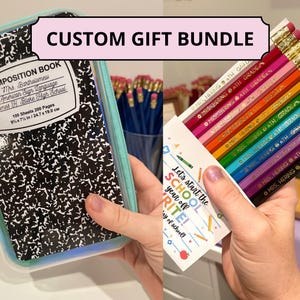 May include: A custom gift bundle featuring a composition book and a set of colored pencils. The composition book is black and white with text that reads "Composition Book" and measures 9x7 inches. The pencils are multi-colored and labeled "Mrs. Hering 4th Grade."