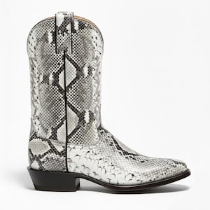 Può includere: Un singolo stivale da cowboy con un motivo a pelle di serpente nei toni del bianco, grigio e nero. Lo stivale ha una punta a punta, un tacco impilato e un gambale a infilare. Lo stivale è in pelle e ha un classico design Western.
