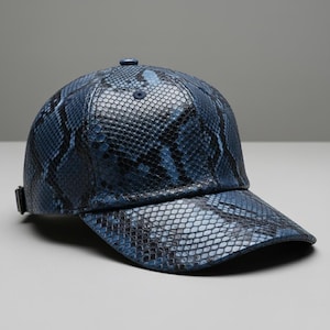 May include: A blue baseball cap with a snakeskin pattern. The cap has a curved peak and an adjustable strap. The hat is made of a textured material and has a button on top.