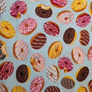 May include: A light blue fabric featuring a repeating pattern of various donuts. The donuts include chocolate, strawberry, and vanilla glazed options with colorful sprinkles, icing drizzles, and some showing a bite taken out of the side.