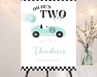 May include: A birthday party welcome sign with the text "Oh He's Two Fast" and "Welcome to Theodore's Birthday Party!" A light blue race car with the number 2 and two balloons is featured. The sign has a black and white checkered border.