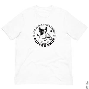 Puede incluir: Camiseta blanca con un diseño en blanco y negro de un bulldog francés sosteniendo una taza de café. El diseño incluye el texto "LIFE BEGINS AFTER COFFEE" y "COFFEE SHOP" en un círculo, con "ESTD 1978".