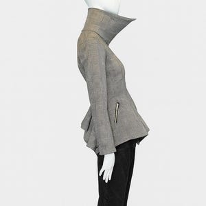 May include: A black and white plaid jacket with a high collar and peplum detail. The jacket has a zipper on the sleeve and is paired with black pants. The mannequin is on a white background.