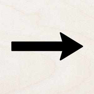 May include: A solid black arrow pointing to the right, set against a light wood grain background. The arrow's design is simple and graphic, with a rectangular shaft and a triangular arrowhead.